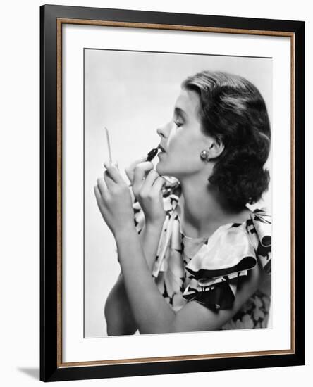 Young Woman Looking into a Mirror and Putting on Make Up-null-Framed Photo