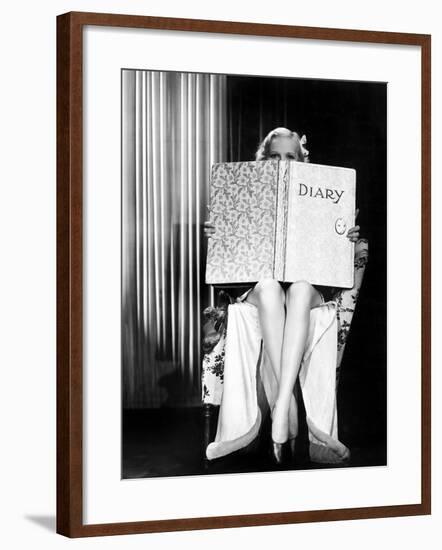 Young Woman Looking over Top of an Oversized Book-null-Framed Photo