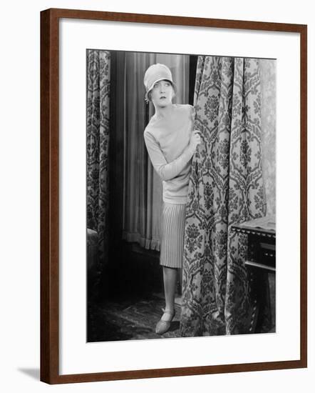 Young Woman Looking Surprised Behind a Curtain-null-Framed Photo