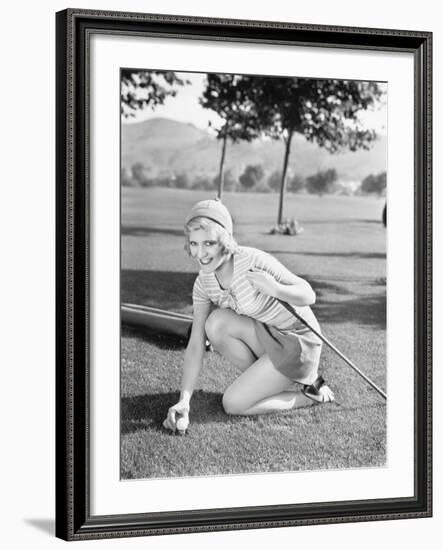 Young Woman on a Golf Course Placing a Golf Ball-null-Framed Photo