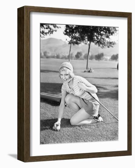 Young Woman on a Golf Course Placing a Golf Ball-null-Framed Photo