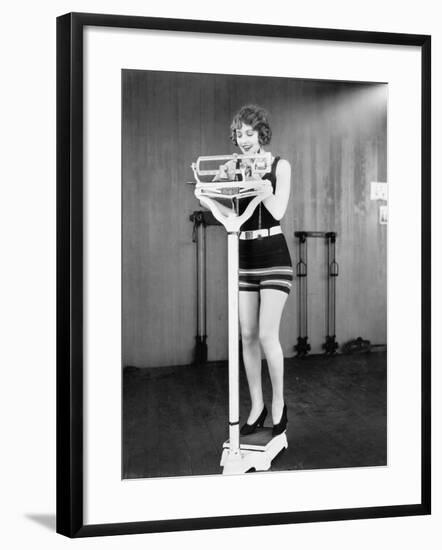 Young Woman on a Scale Taking Her Weight-null-Framed Photo