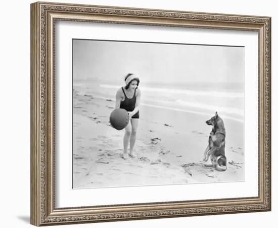 Young Woman Playing with Her Dog and Ball on the Beach-null-Framed Photo