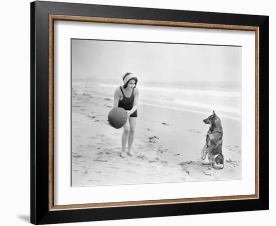 Young Woman Playing with Her Dog and Ball on the Beach-null-Framed Photo