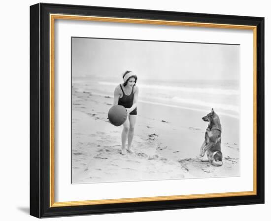 Young Woman Playing with Her Dog and Ball on the Beach-null-Framed Photo