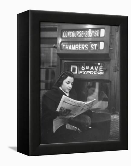 Young Woman Wearing a Winter Coat and Hat, Reading Beneath "D 6th Avenue" Sign, Riding the Subway-Eliot Elisofon-Framed Premier Image Canvas