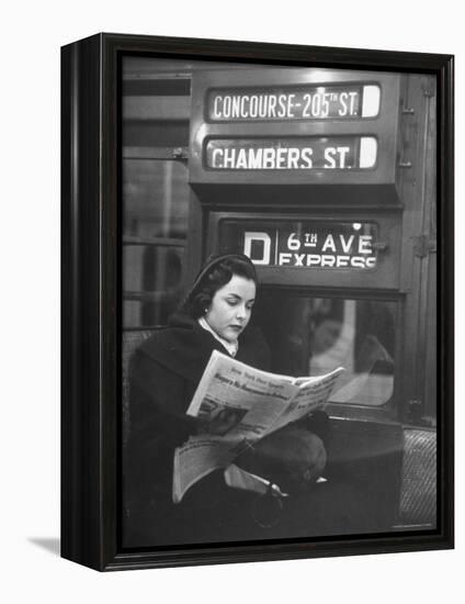 Young Woman Wearing a Winter Coat and Hat, Reading Beneath "D 6th Avenue" Sign, Riding the Subway-Eliot Elisofon-Framed Premier Image Canvas