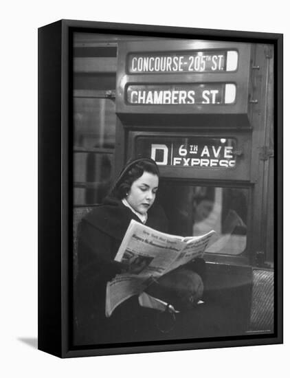 Young Woman Wearing a Winter Coat and Hat, Reading Beneath "D 6th Avenue" Sign, Riding the Subway-Eliot Elisofon-Framed Premier Image Canvas