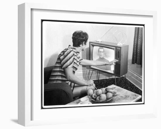 Young Woman with Short Dark Hair Wearing a Stripy Mini Dress Adjusts Her Television Set-null-Framed Art Print