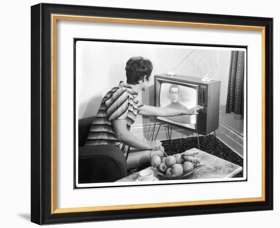 Young Woman with Short Dark Hair Wearing a Stripy Mini Dress Adjusts Her Television Set-null-Framed Art Print