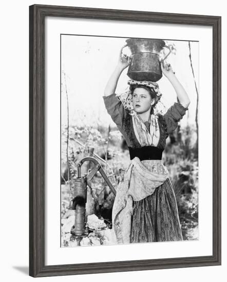 Young Woman with Water Bucket on Her Head Next to a Well-null-Framed Photo