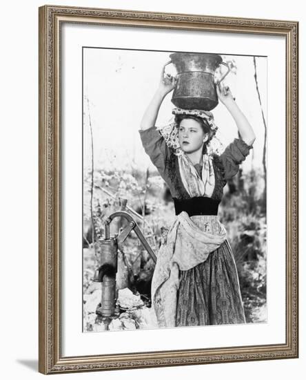 Young Woman with Water Bucket on Her Head Next to a Well-null-Framed Photo