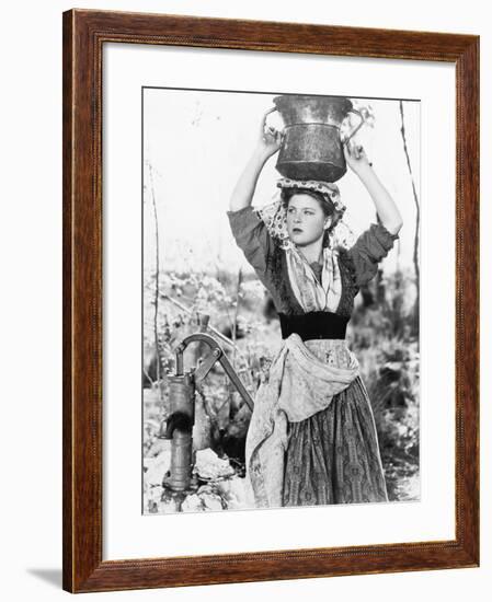Young Woman with Water Bucket on Her Head Next to a Well-null-Framed Photo