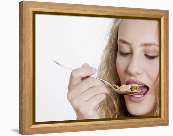 Young Womand Eating Cornflakes from a Spoon-null-Framed Premier Image Canvas