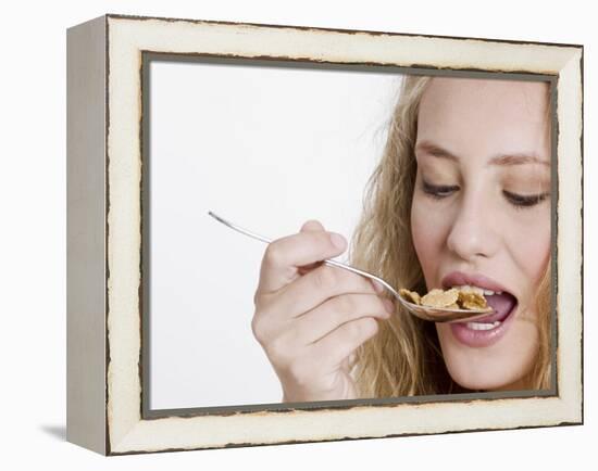 Young Womand Eating Cornflakes from a Spoon-null-Framed Premier Image Canvas