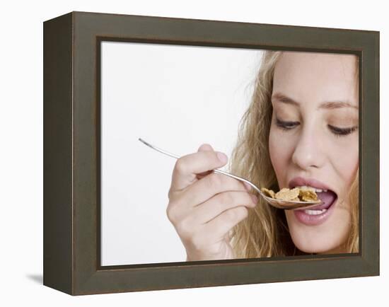 Young Womand Eating Cornflakes from a Spoon-null-Framed Premier Image Canvas