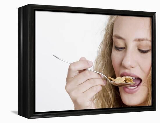 Young Womand Eating Cornflakes from a Spoon-null-Framed Premier Image Canvas