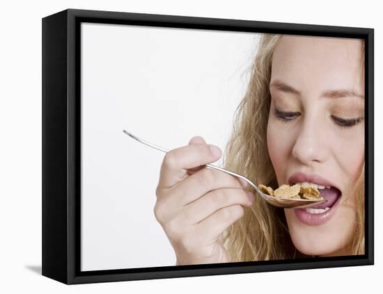 Young Womand Eating Cornflakes from a Spoon-null-Framed Premier Image Canvas