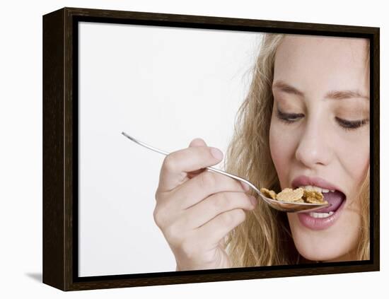Young Womand Eating Cornflakes from a Spoon-null-Framed Premier Image Canvas