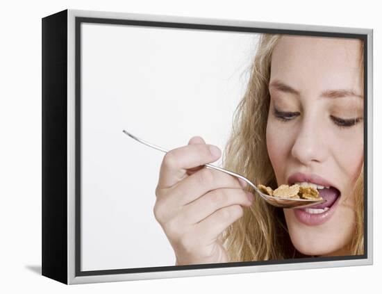 Young Womand Eating Cornflakes from a Spoon-null-Framed Premier Image Canvas