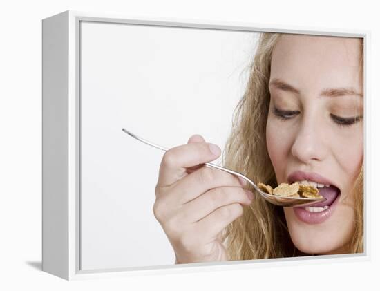 Young Womand Eating Cornflakes from a Spoon-null-Framed Premier Image Canvas