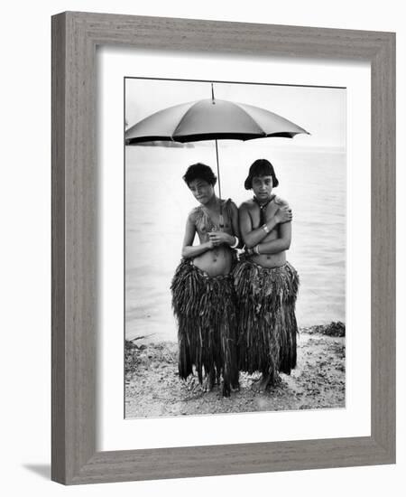 Young Yap Island ladies sporting traditional Grass Skirts, Sharing umbrella in the Caroline Islands-Eliot Elisofon-Framed Photographic Print